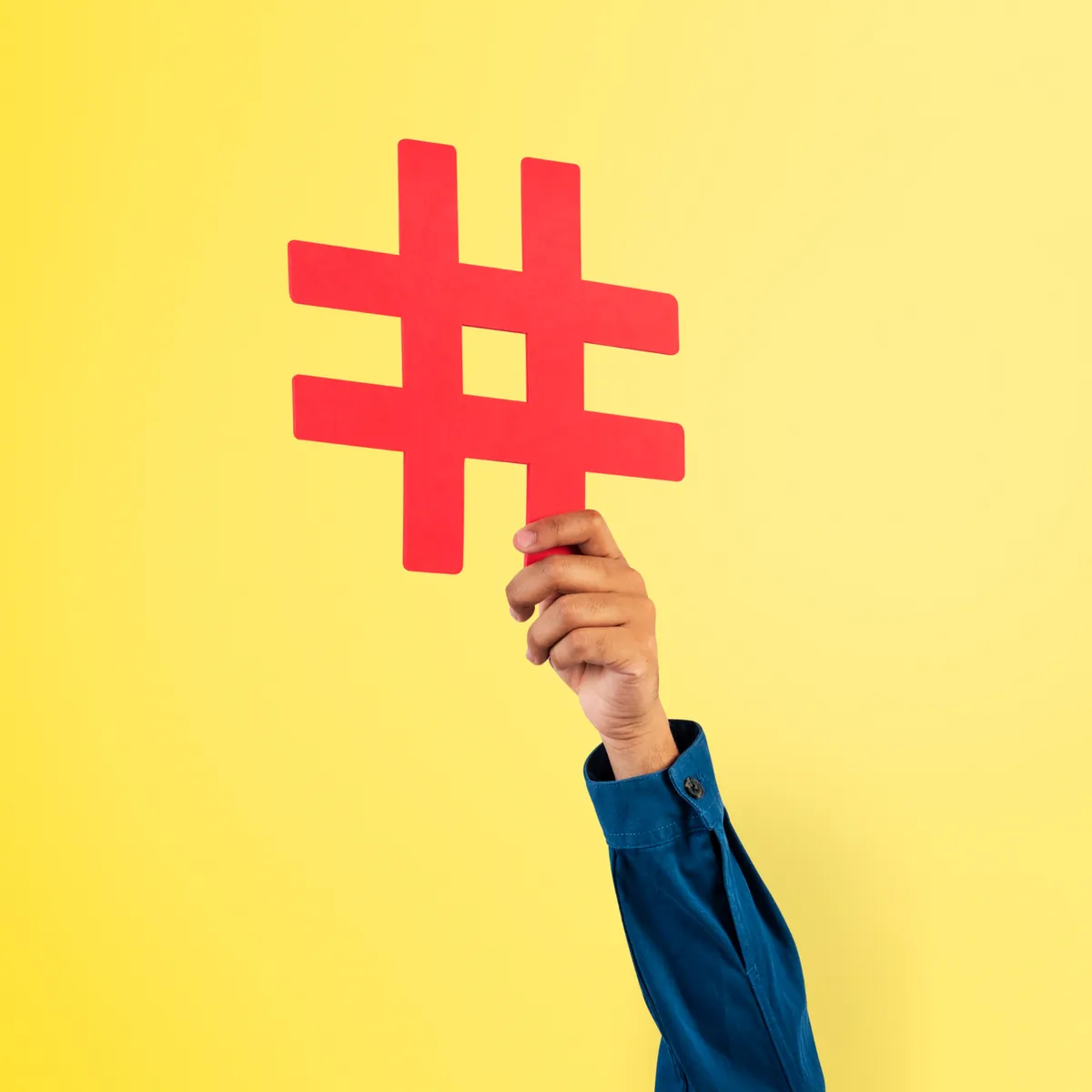Mano sosteniendo un símbolo numeral, idea de hashtags en redes sociales